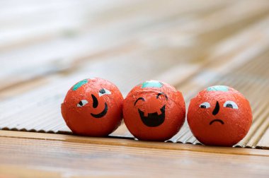 Cadılar Bayramı dekorasyonu arka planında üç balkabağı şekeri ev ahşap terasında duygu dolu yüzler var. 