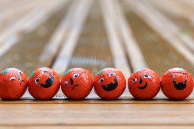 Cadılar Bayramı dekorasyonları arka planda bir sıra balkabağı şekerlemeleri ahşap terasta duygu yüzlü şekerler 