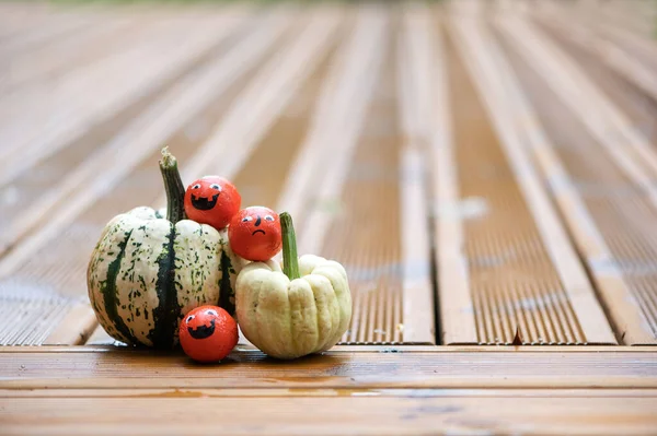 Cadılar Bayramı dekorasyonları balkabakları ve şekerlerle ahşap terasta duygu dolu yüzler 