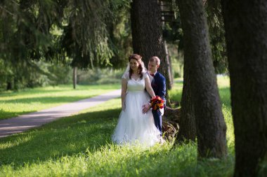 Damat gelinin eline uzanırken, kırmızı duman orman yolunu arkalarından dolduruyor.