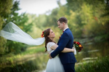 Genç gelin ve damat birbirine sıkıca sarılır. Sakin bir düğün anını paylaşırlar. Aşk, huzur ve duygusal bir bağ..