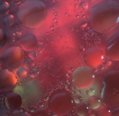 Yatay sanatsal yağ ve su soyutlaması yumuşak yüzen daireler, parıldayan mikro baloncuklar ve metin için dramatik siyah boşluk.