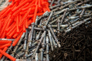 Çeşitli vidaların yatay görüntüsü çapalar ve duvar tıkaçları karşıt kısımlarda düzenlenmiş düzen dokusu ve inşaat malzemelerini vurguluyor.