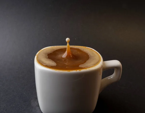 closeup photo of coffee drop in a cup