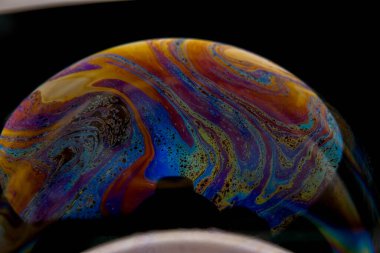 Sabun köpüğünün yüzeyindeki renkli ışık yansımasının yakın plan fotoğrafı