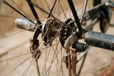 Bisiklet arka tekerleğinin yakın çekimi vites ve fren sistemini gösteriyor, karmaşık mekanik ve bisiklet ekipmanlarının detaylarını vurguluyor