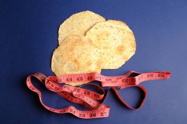 Üç yuvarlak, düz tortilla mavi bir arka plana yerleştirilmiş pembe bir mezura ile çevrelenmiş.