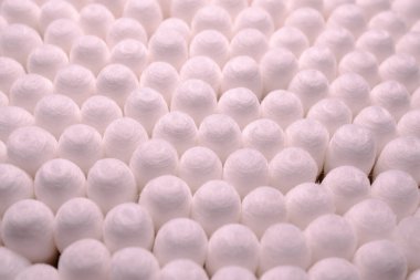 Beyaz uçlarını ve silindirik şekillerini gösteren, tek bir desen halinde dizilmiş sayısız pamuktan örnekler.