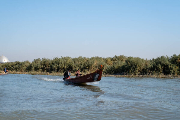 Насирия, Ирак - 20 ноября 2025 года: Традиционная лодка "Машуф", перевозящая пассажиров по болотному водному пути