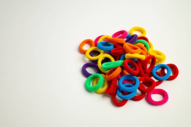 Beyaz arka planda çeşitli şekil ve boyutlarda renkli elastik saç bağları.