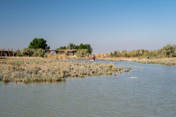 Насирия, Ирак - 20 ноября 2025 года: Группа туристов на традиционных лодках Машуф приближается к памятнику Аль-Шахиду в Чибаишских болотах