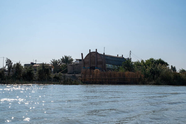 Насирия, Ирак - 20 ноября 2025 года: Группа туристов на традиционных лодках Машуф приближается к памятнику Аль-Шахиду в Чибаишских болотах