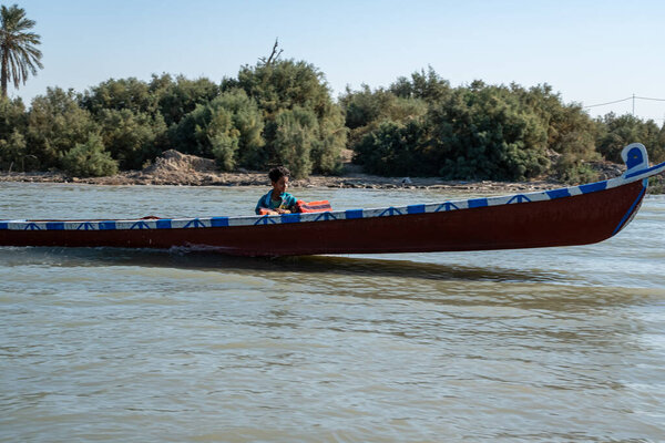 Насирия, Ирак - 20 ноября 2025 года: Группа туристов на традиционных лодках Машуф приближается к памятнику Аль-Шахиду в Чибаишских болотах