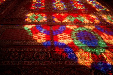 Renkli cam yansımaları desenli bir halıda