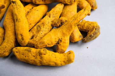Etkili bir baharat, boya ve doğal takviye olarak kullanılan kurutulmuş sarı-turuncu zerdeçal parmaklar (Curcuma longa) Makro yakın çekim.