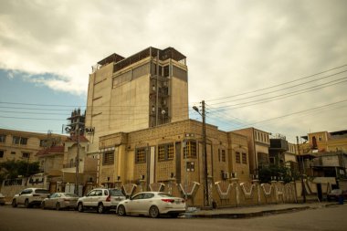 Park halindeki arabaları ve bulutlu bir gökyüzü altında klasik mimarisi olan temiz bir şehir caddesinin geniş açılı perspektifi..