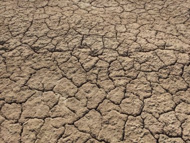 Kuru toprak yüzeyi çatlamış, kuraklık ve kuraklık örnekleri gösteriyor.
