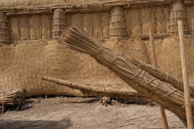 Dokuma kamış ve samandan yapılmış geleneksel bir yapıya yakından bakmak doğal malzemelerin dokusunu ve işçiliğini gözler önüne seriyor.