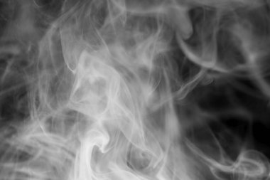 Abstract black and white smoke patterns swirling in the air