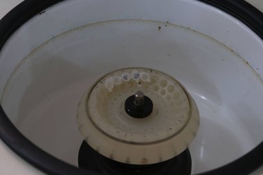 Laboratuvar santrifüjünün içindeki santrifüj pervanesinin yakından görüntüsü pervaneyi birkaç örnek tüpüyle gösteriyor.