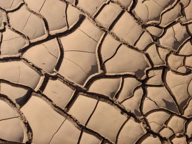 Çatlak kuru toprağa yakın çekim, karmaşık desenler ve dokular sergiliyor.