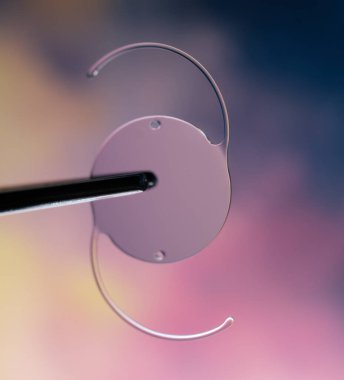 İki kavisli kollu, muhtemelen tıbbi ya da bilimsel bir aletle renkli bulanık bir arka plana karşı dairesel bir cihazın yakın çekimi.