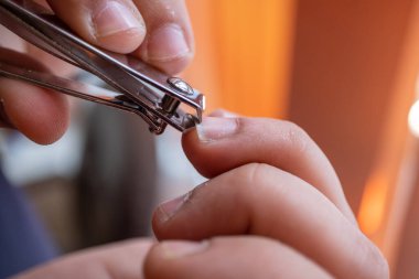 Tırnak makasıyla tırnak kesme hareketine odaklanan birinin yakın çekimi.