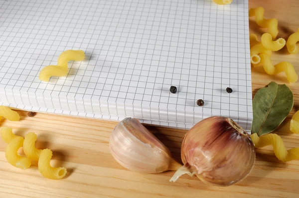 Bloc-notes sur fond de pâtes, tomates et épices — Photo