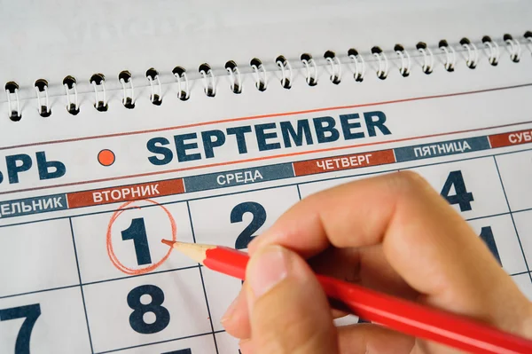 Дата 1 вересня на календарі, округленому рукою червоного кола — стокове фото