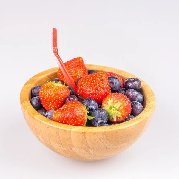 Erdbeeren und Blaubeeren im Holzbecher mit Stroh — Stockfoto