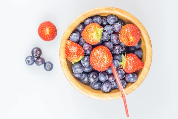 Erdbeeren und Blaubeeren im Holzbecher mit Stroh — Stockfoto