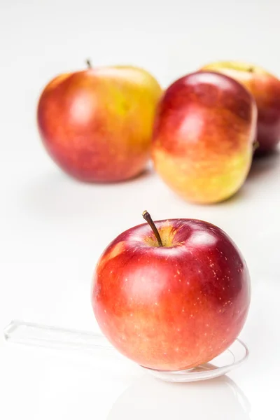 Roter Apfel auf durchscheinendem Medizinlöffel auf dem Tisch — Stockfoto