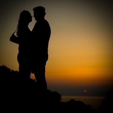 Genç bir kıyısında günbatımı kızdırma tatil sırasında Girit plaj çift.