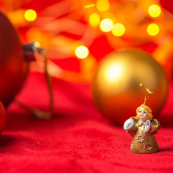 Christmas angel and balls on red background with bright yellow lights — Stock Photo, Image