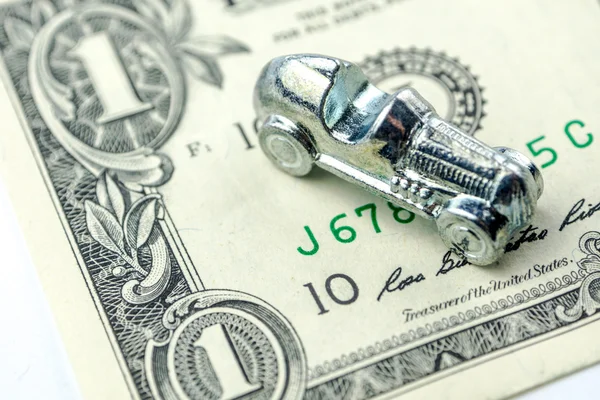 Little car made of chrome is laying on one dollar banknote — Stock Photo, Image