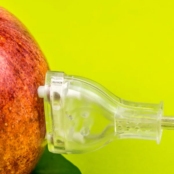 Doorschijnende stekker is aangesloten op de rode appel op groene achtergrond — Stockfoto