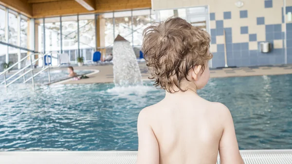 Kind schaut auf die andere Seite des Hallenbades — Stockfoto