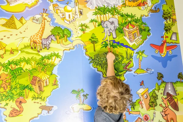 Child is traveling with a stick on the map of the world — Stock Photo, Image