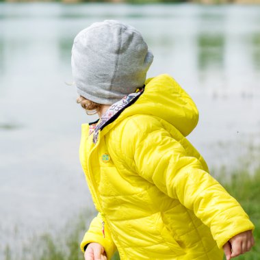 Çocuk bir göl kıyısında oynuyor