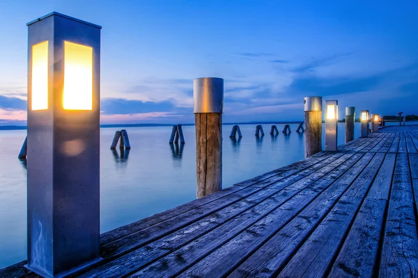 Lighted wooden pier — Stock Photo, Image