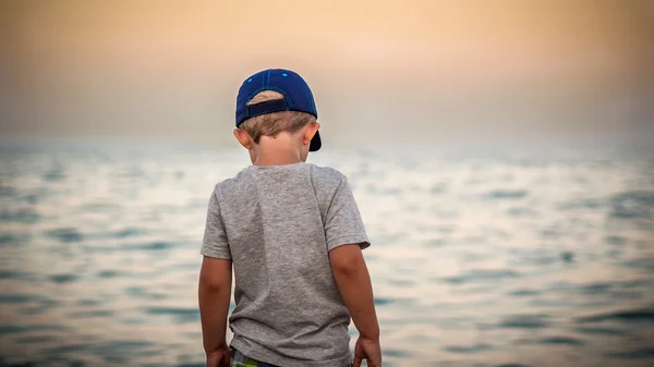 Boy is watching evening sea — Stock Photo, Image