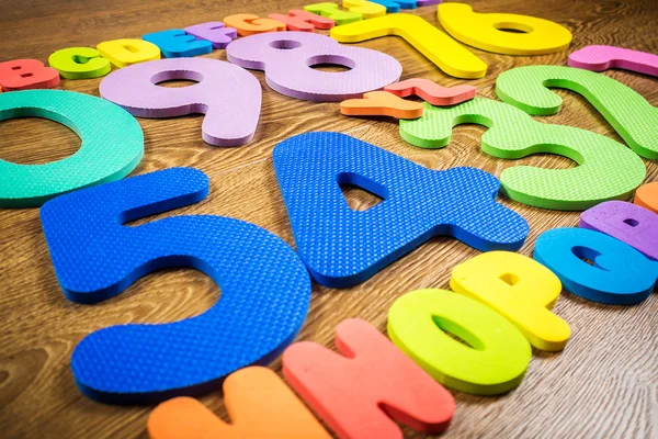 Numeri di plastica e lettere su sfondo di legno — Foto Stock