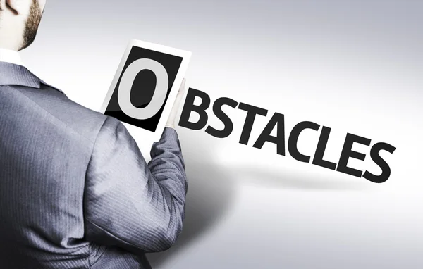Hombre de negocios con el texto Obstáculos en una imagen conceptual —  Fotos de Stock