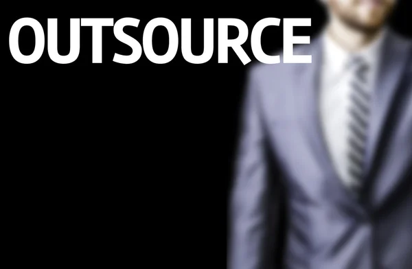 Outsource written on a board with a business man — Stock Photo, Image