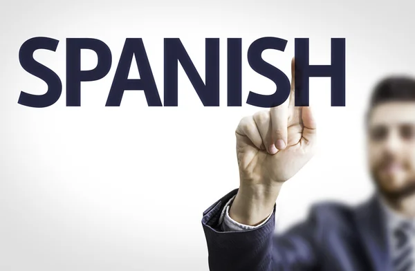 Business man pointing to board with text: Spanish — Stock Photo, Image