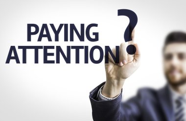 Business man pointing the text: Paying Attention? clipart