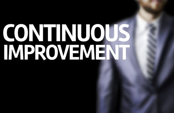 Continuous Improvement written on a board with a business man — Stock Photo, Image