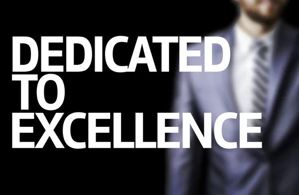 Dedicated to Excellence written on a board with a business man — Stock Photo, Image