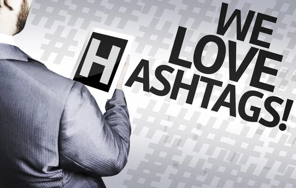 Geschäftsmann mit dem Text, den wir lieben Hashtags in einem Konzeptbild — Stockfoto