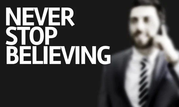 Hombre de negocios con el texto Never Stop Believing in a concept image — Foto de Stock